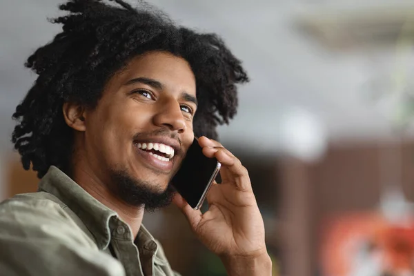 이동 전화. ( 영어 ) Closeup Shot Of Smiling Black Guy Talking On Cellphone Indoor — 스톡 사진