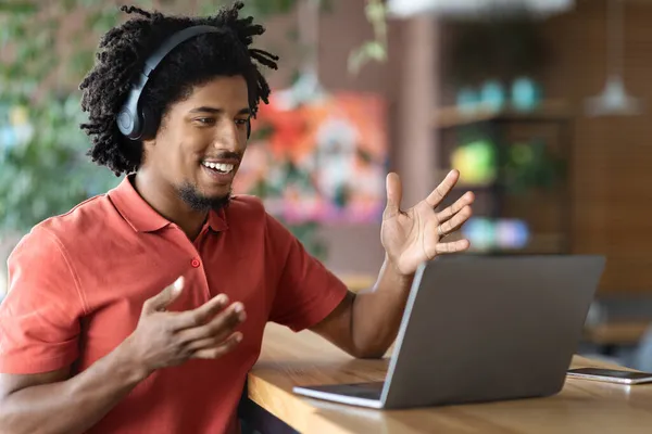 カフェでノートパソコンでビデオ通話をする若い黒人男性 — ストック写真
