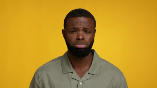 Смішний молодий чорний чоловік штовхає губу і дивиться на камеру — стокове відео