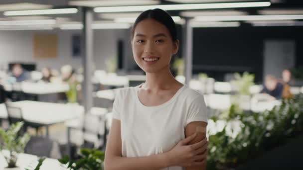 Gelukkig gevaccineerde aziatische vrouw poseren na covid-19 vaccinatie in office — Stockvideo