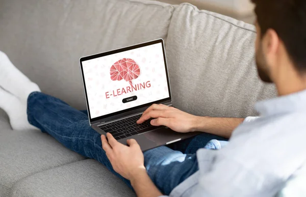 Estudio remoto. Hombre hojeando el sitio web de E-Learning en el ordenador portátil, teniendo lecciones en línea —  Fotos de Stock