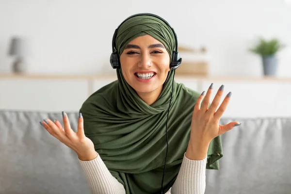 Happy young Arab woman in hijab speaking to friend on webcam, having remote video call from home, pc screen view — Stok Foto