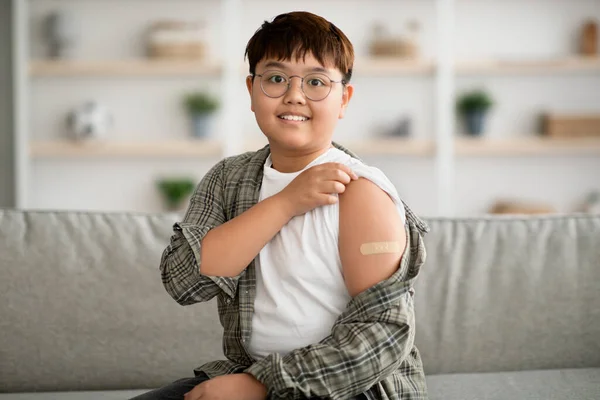 Cute plump korean kid got vaccinated, showing adhesive band — Stock Photo, Image