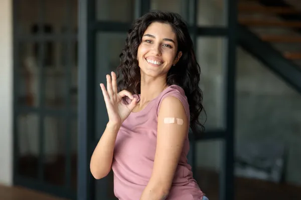 Мила кавказька жінка з клейкою штукатуркою на плечах після вакцинації вінцевих артерій. — стокове фото