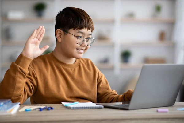 Uśmiechnięty koreański pulchny chłopiec macha na laptop ekran — Zdjęcie stockowe