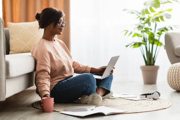 Nero signora utilizzando computer portatile lavoro e avendo caffè a casa — Foto Stock