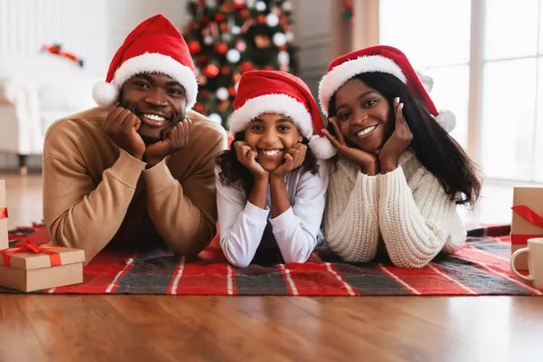 Glad svart familj i Santa claus hattar firar jul — Stockfoto