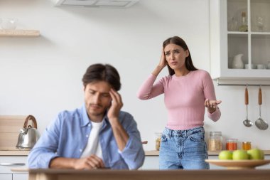 Üzgün, mutsuz, bin yıllık Kafkasyalı koca, minimalist mutfağın içinde kızgın, çığlık atan karısını görmezden geliyor.