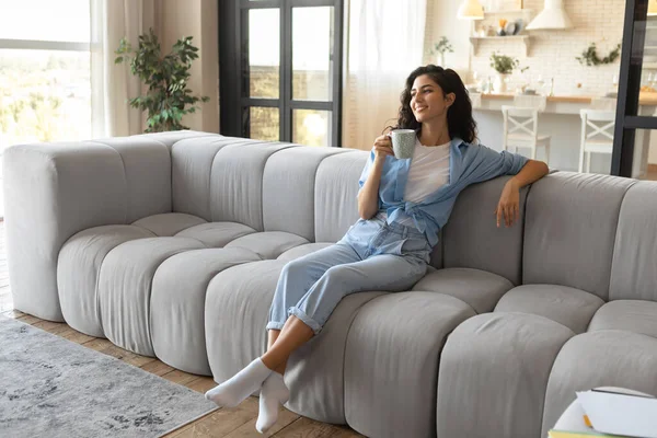 Attraktiv vit kvinna njuter lat morgon med kaffe i vardagsrummet, kopiera utrymme — Stockfoto