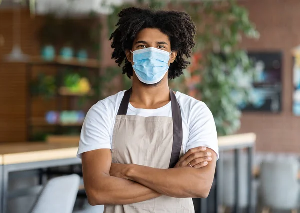 Young Black Barista Wearing Apron And Medical Mask Posing In Cafe Interior — Stock Photo, Image