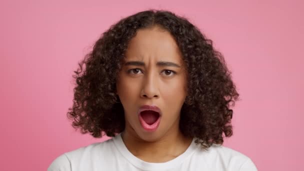 Retrato de mujer afroamericana bostezando sobre fondo rosa — Vídeos de Stock