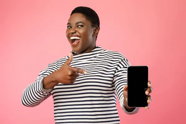 Örömteli fekete nő mutatja Smartphone üres képernyő felett rózsaszín háttér — Stock Fotó