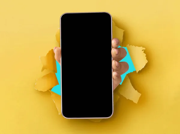 Dáma ukazuje bílou prázdnou obrazovku smartphonu prolamující papír — Stock fotografie