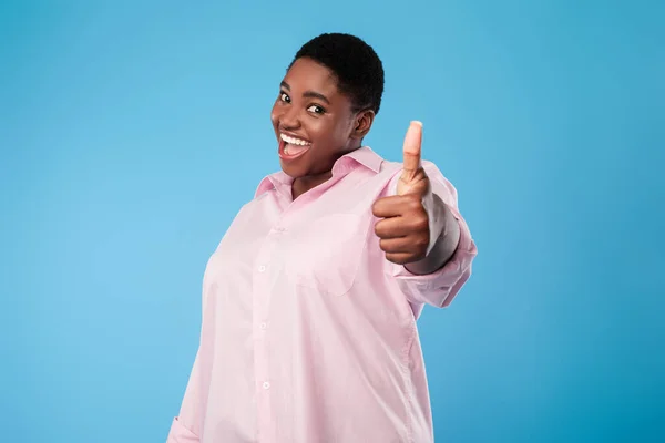 Opgewonden overgewicht Afro-Amerikaanse vrouw Gesturing Thumbs Up, Blauwe achtergrond — Stockfoto