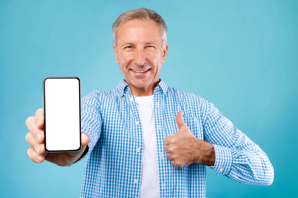 Чоловік показує білий порожній екран смартфона і великі пальці вгору — стокове фото