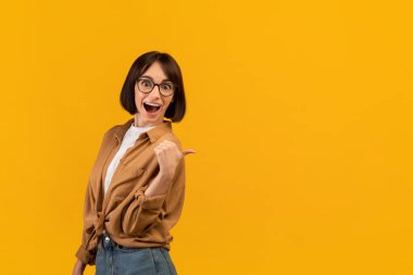 Harika bir teklif. Heyecanlı genç beyaz kadın kameraya bakarak fotokopi alanını işaret ediyor.