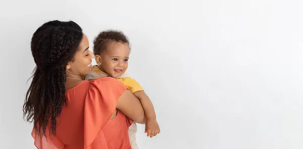 Материнская любовь. Афроамериканка позирует с милым малышом на руках — стоковое фото