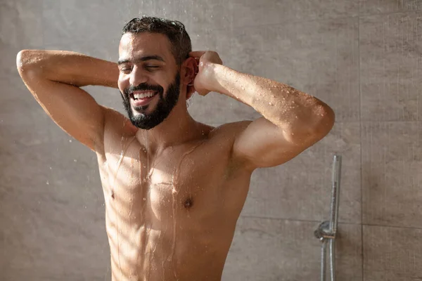 Yakışıklı genç Arap erkek model sıcak duş almanın keyfini çıkarıyor. — Stok fotoğraf