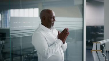 Düşünme Süreci. Düşünceli Siyah Erkek Girişimci Elleri ovuşturuyor, İş Merkezinde Duruyor