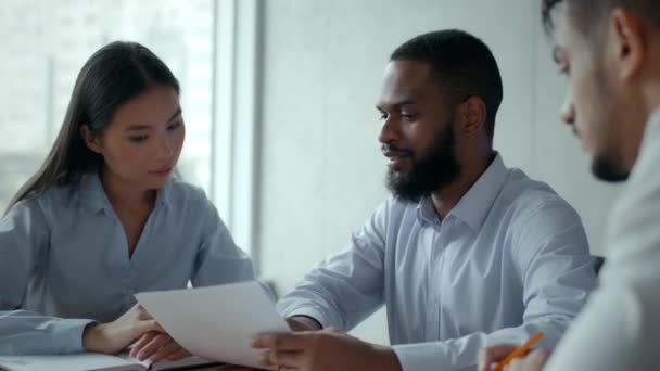 Affärsförhandlingar. Multietniskt företagsteam diskuterar ny strategi på kontoret, granskar finansiella dokument — Stockvideo