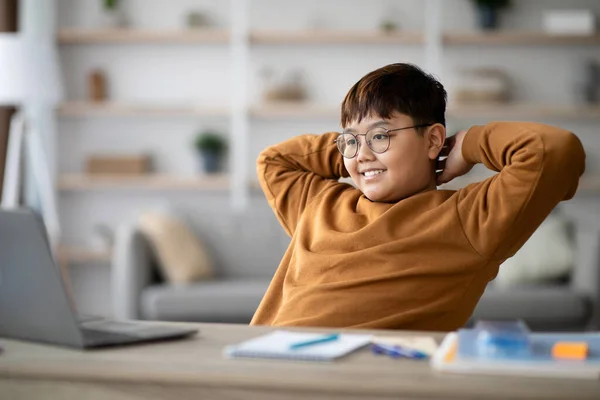Zrelaksowany azjatycki chłopiec patrząc na ekran notebooka i uśmiechnięty — Zdjęcie stockowe