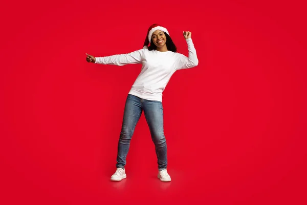Mulher negra atraente em Santa chapéu dançando no vermelho — Fotografia de Stock