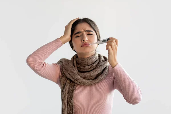 Verstoorde millennial indiaanse dame in sjaal meet temperatuur met thermometer in de mond en lijdt aan hoofdpijn — Stockfoto
