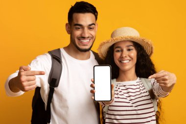 Seyahat Rezervasyonu Çevrimiçi. Mutlu Arap Gezginler Boş Akıllı Telefonu Gösteren Çift
