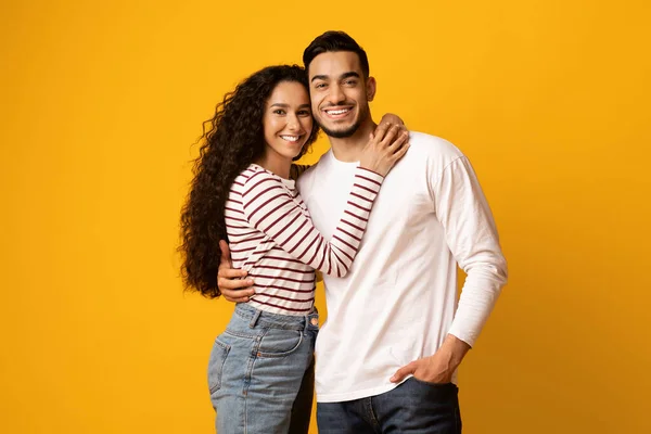 Ρομαντικό ζευγάρι. Ευτυχισμένη Μέση Ανατολή Άνδρας και γυναίκα αγκαλιάζει σε κίτρινο φόντο — Φωτογραφία Αρχείου