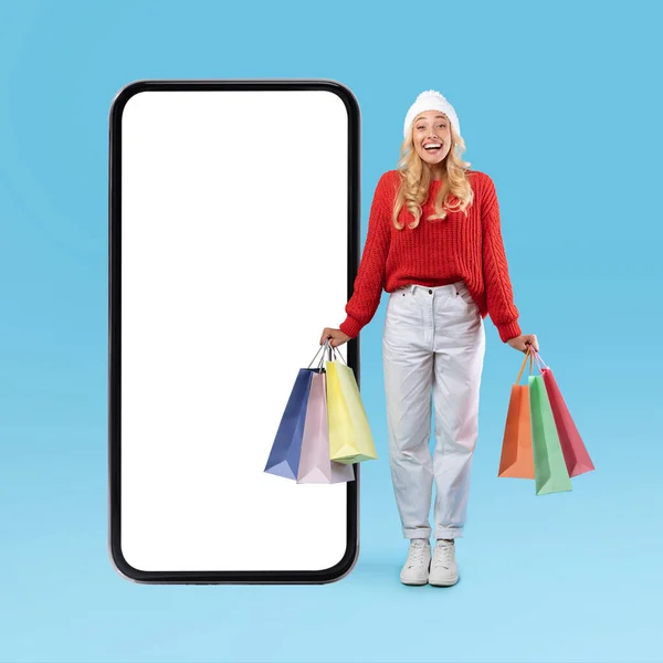 Cliente femminile in posa con sacchetti bianchi vuoti dello schermo dello smartphone — Foto Stock
