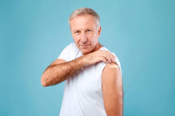 Щасливий вакцинований чоловік з клейкою пов'язкою — стокове фото