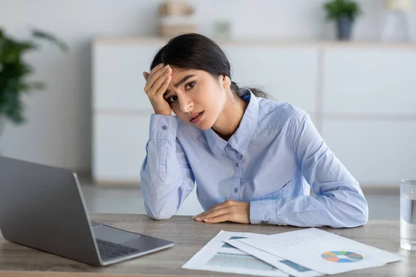 Mutsuz genç Hintli kadın yönetici el ele verip dizüstü bilgisayara bakıyor, ofiste baş ağrısı çekiyor. — Stok fotoğraf