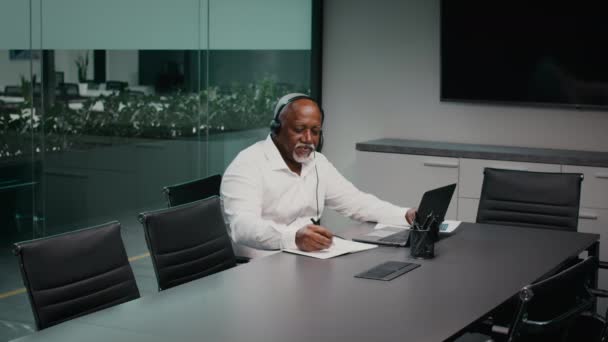 Obchodní výchova. Starší černošky podnikatel sledování Webinar a psaní poznámek v kanceláři — Stock video