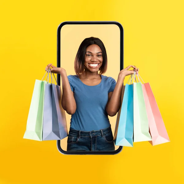 Eccitato nero donna coming out schermo con shopping bags — Foto Stock