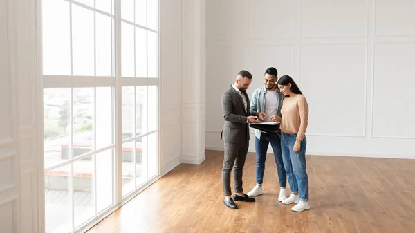 Pareja Comprando Apartamento Nuevo, Casa Agente Mostrando Documentos Planos — Foto de Stock