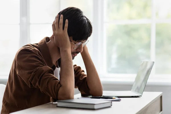 Trauriger Mann aus dem Nahen Osten leidet unter Kopfschmerzen im Büro — Stockfoto