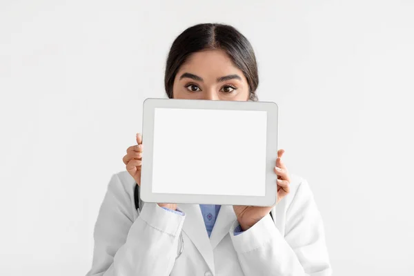 Beyaz arka planda izole edilmiş beyaz ekran tabletli genç Hintli doktor. — Stok fotoğraf