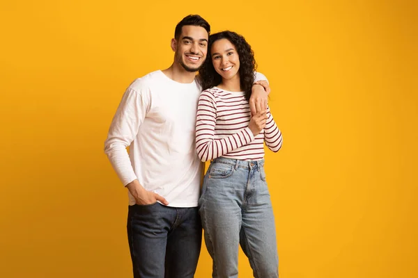 Sarı arka planda poz veren mutlu ortadoğulu çiftin portresi — Stok fotoğraf