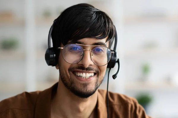 Close-up portret van gelukkige indiaanse man met behulp van headset — Stockfoto