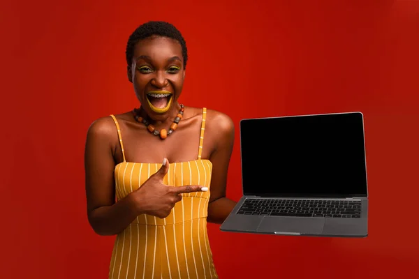 Эмоциональный стильный африканский американец показывает ноутбук с пустым экраном — стоковое фото