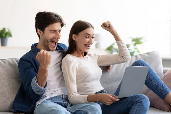 Felice sorridente eccitato giovane europeo maschio e donna che celebra la vittoria nel gioco online sul computer portatile — Foto Stock