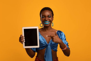 Sayısal tableti boş ekranla gösteren şık siyah kadın