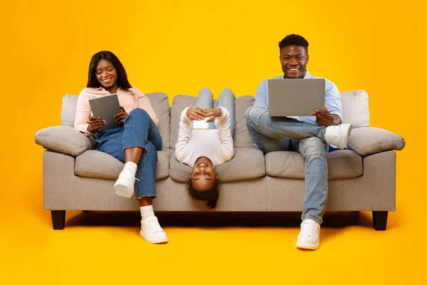 Šťastné africké americké rodiny držení a používání gadgets — Stock fotografie