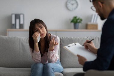 Depresyon danışmanı. Psikoterapi ofisinde terapi seansında ağlayan mutsuz Arap kadın sorunlarını paylaşıyor.