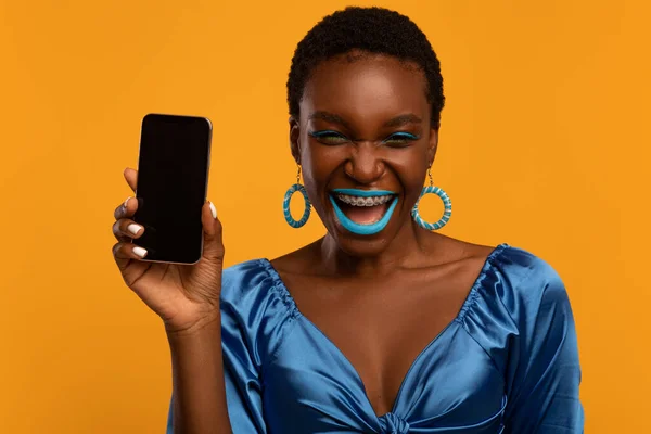 Счастливая стильная чернокожая женщина показывает мобильный телефон с экраном — стоковое фото