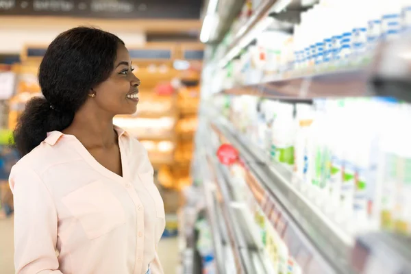 アフリカの女性がスーパーで乳製品を見て棚ショッピング — ストック写真
