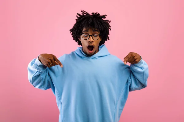 Look at this. Shocked black teen guy pointing down with two fingers on pink studio background — Stock Photo, Image