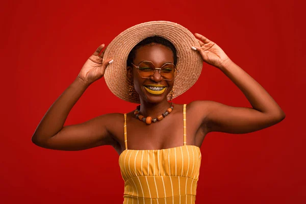 Mujer negra feliz en traje de verano posando en rojo — Foto de Stock