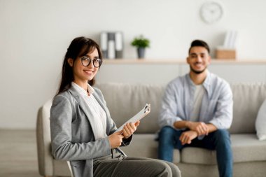Ofiste etkili bir terapiden sonra gülümseyen mutlu kadın psikolog ve genç Arap adam, boş alan. Başarılı tedavi