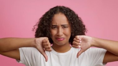 Siyah Kadın İşaret Ediyor İki Elle Başparmakları Aşağı, Pembe Arkaplan